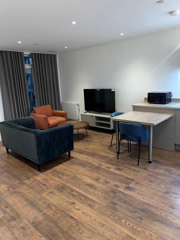 a living room with a couch and a table and a tv at Unique Homes in Barking