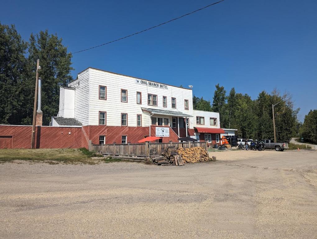 a white building with a fence in front of it at Coal Branch Hotel & Restaurant in Coalspur