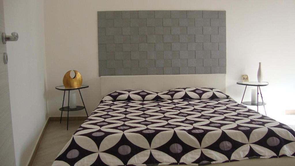 ノートにあるMannarazzi Casa Vacanzaのベッドルーム1室(ベッド1台、白黒の掛け布団付)