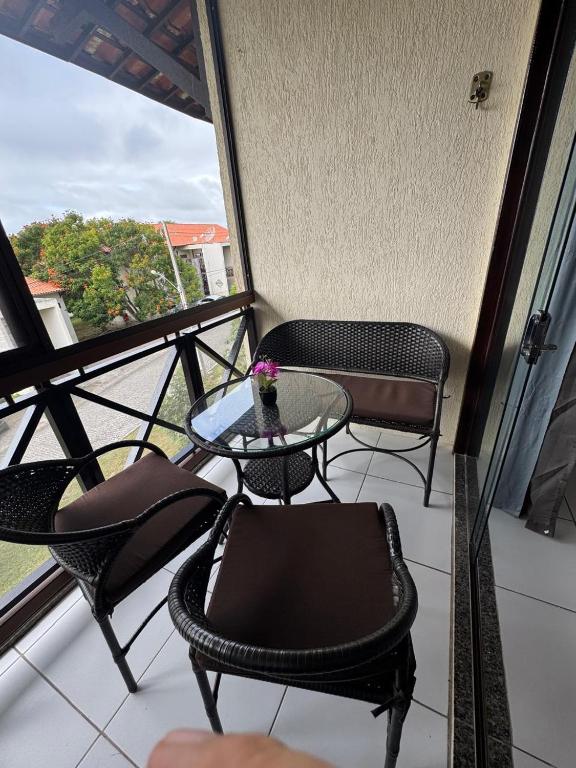 Un balcón con una mesa y sillas y una ventana. en Flat Monte Castelo, en Sairé