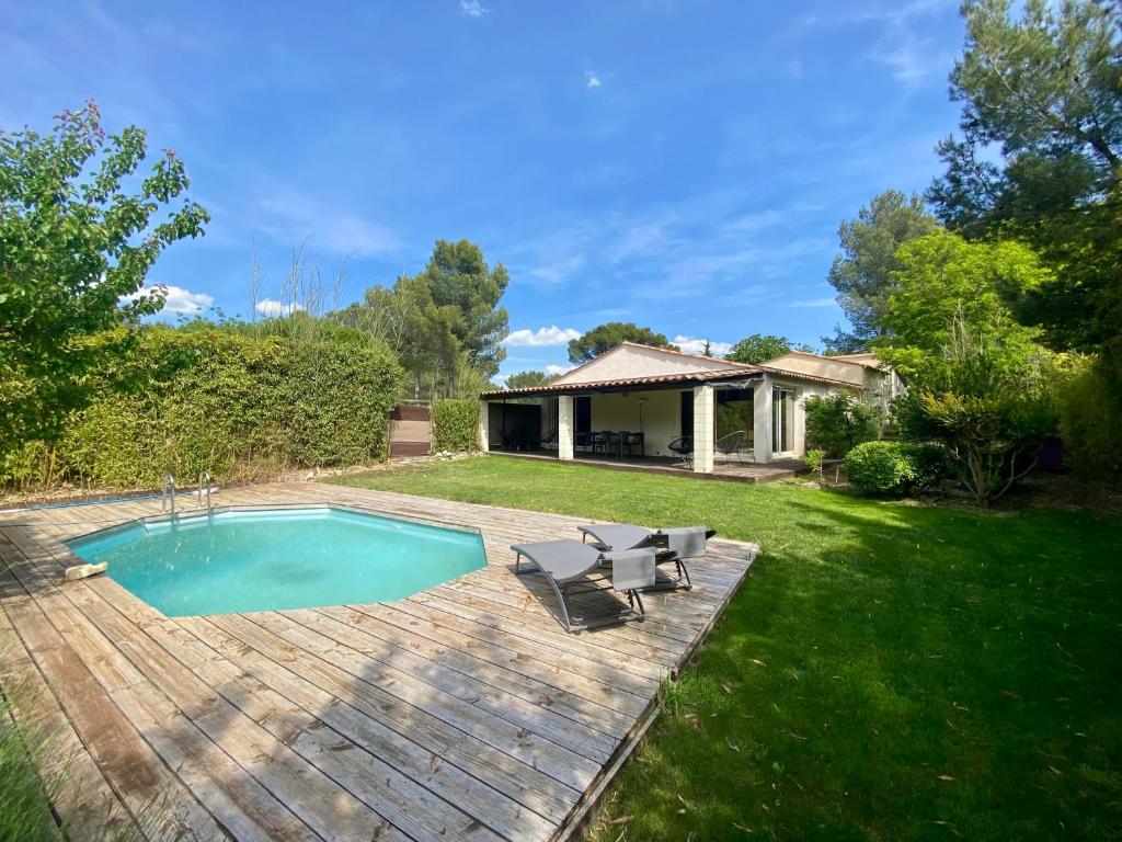 a backyard with a swimming pool and a house at Villa de vacances nichée dans la Garrigues, à 10 minutes d'Avignon in Villeneuve-lès-Avignon