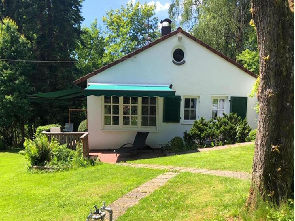 a small white house with a green roof at Landhaus Weickenhof Comfortable holiday residence in Oberweickenhof