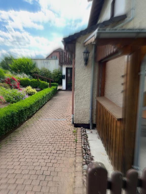 a brick walkway next to a building with a door at Auszeit in Lügde