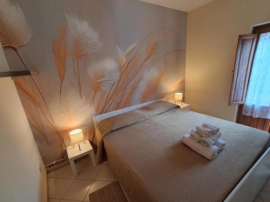 a bedroom with a bed with towels on it at Lo SCRIGNO in San Giorgio Montagna