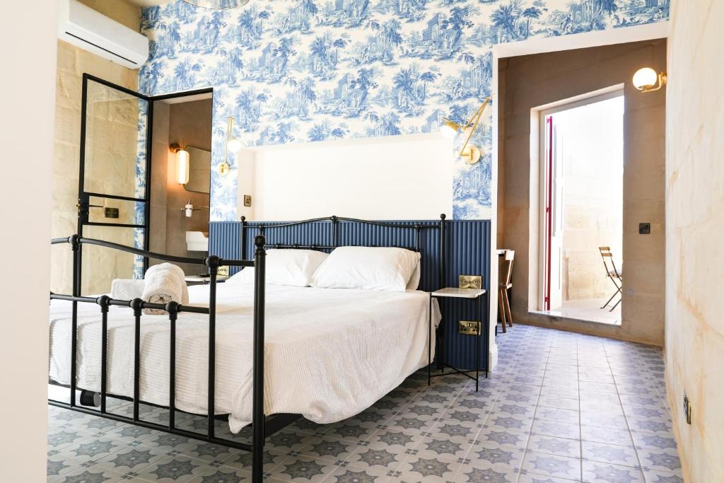 una camera da letto con un letto con carta da parati blu di No 14 House a Żejtun