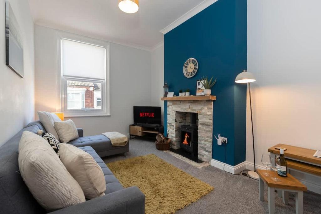 ein Wohnzimmer mit Couch und Kamin in der Unterkunft Central Saltburn 2 bed family apartment in Saltburn-by-the-Sea