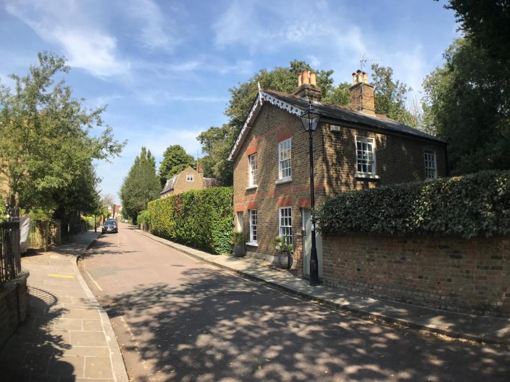 ein altes Backsteinhaus am Straßenrand in der Unterkunft Garden Cottage in Twickenham