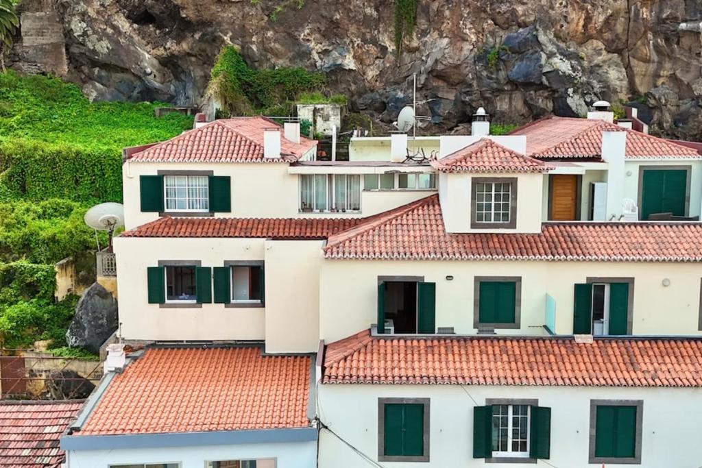 a group of white houses with red roofs at Serena Bay in Câmara de Lobos