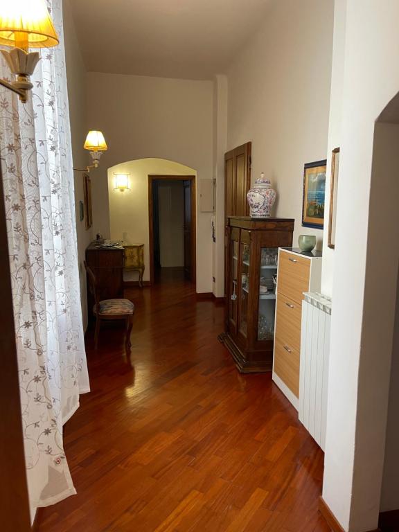 Una sala de estar con piso de madera y una cómoda. en Serena House, en Florencia