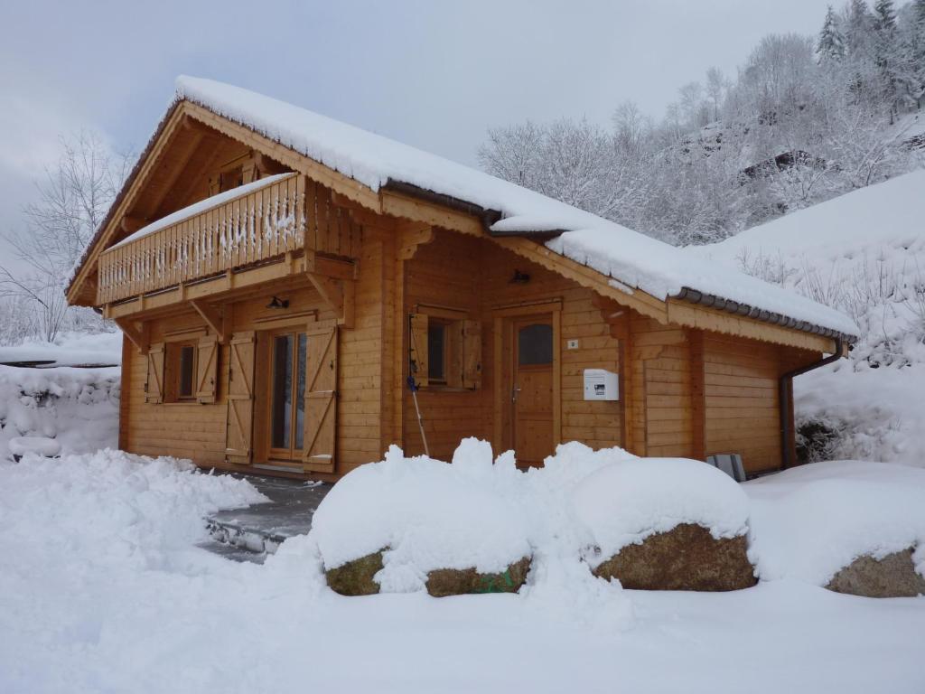 una cabaña de troncos con nieve en el techo en Les Noisettes, en La Bresse