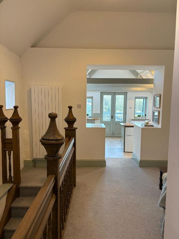 a living room with a staircase and a kitchen at Merchants House in Penryn