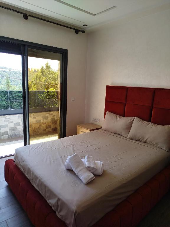 a bedroom with a large bed with a red headboard at Le Refuge de Vittel 2 in Ifrane