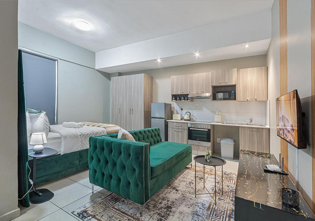 sala de estar con cama y sofá verde en Charming Studio & Backup Power, en Johannesburgo