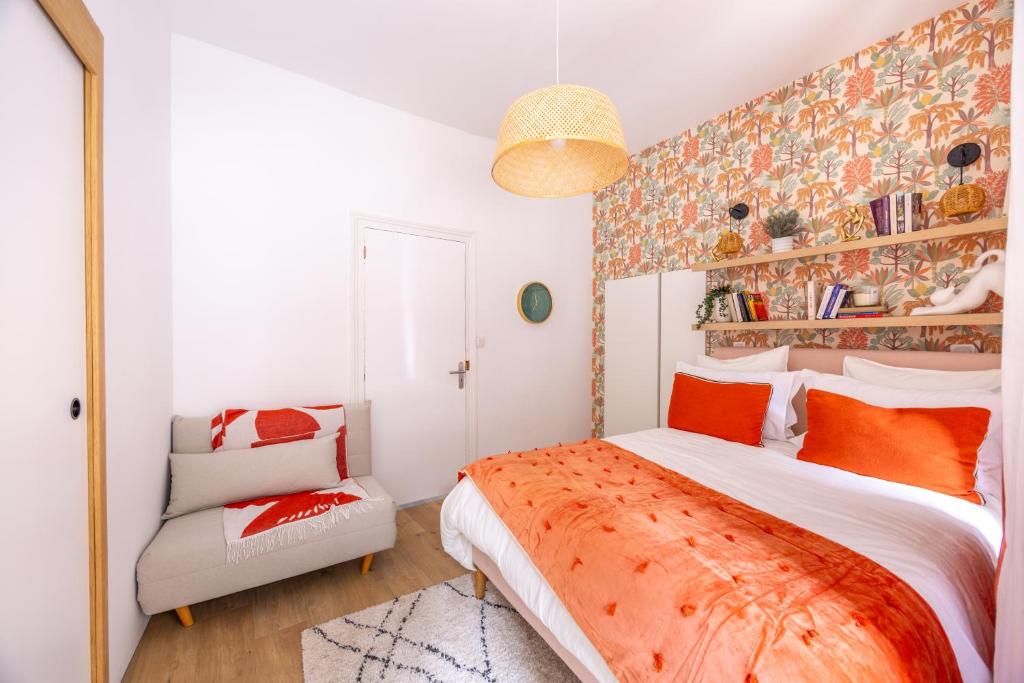 une chambre avec un grand lit et une chaise dans l'établissement Gîte du Bon-Secours, à Saint-Malo