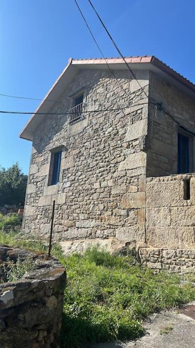 a stone building with a window on the side of it at Casa Santiago in Ézaro