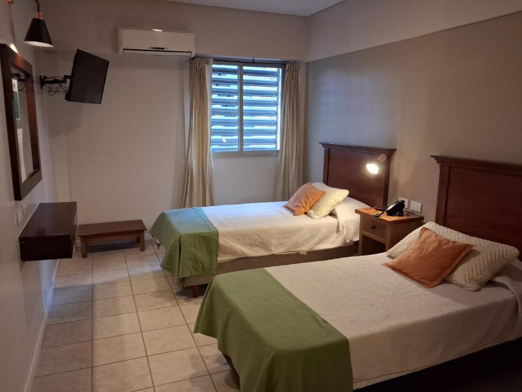 a hotel room with two beds and a window at Esmeralda Palace Hotel in Buenos Aires
