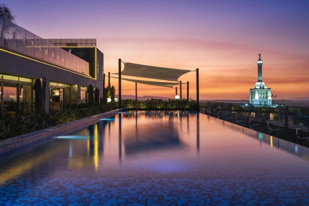 a pool with a view of the eiffel tower at AC Hotel by Marriott Santiago de los Caballeros in Santiago de los Caballeros