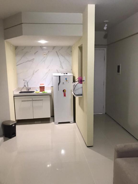 a kitchen with a refrigerator in the middle of a room at Condominio Biarritz Flat Residence in São Luís
