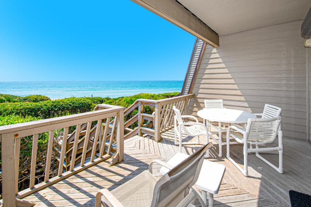 a porch with a table and chairs and the ocean at PKOG09 Ocean Grove G4 in Pine Knoll Shores
