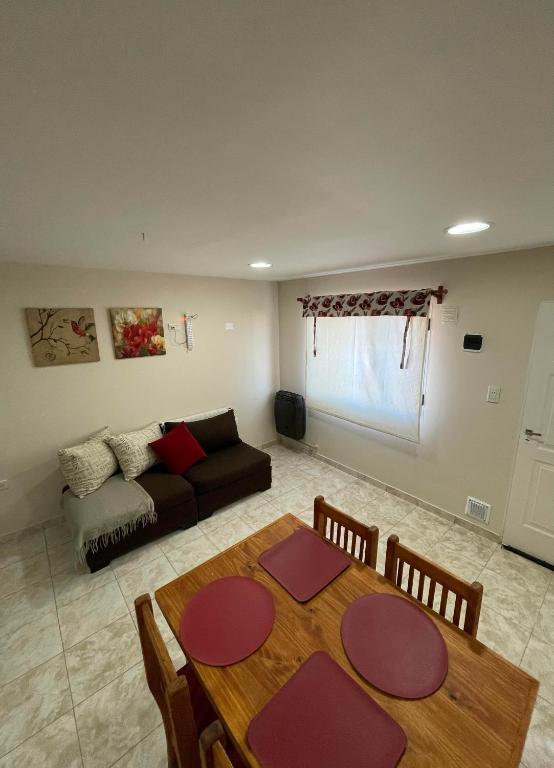 una sala de estar con una mesa y un sofá en Refugio Kooch, en Río Gallegos