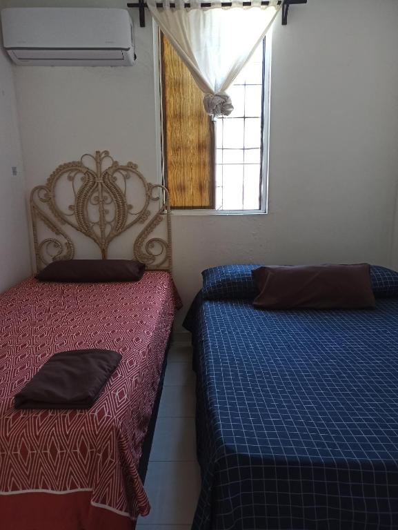 a bedroom with two beds and a window at Hospedaje a 10 min de aeropuerto Internacional de Monterrey in Monterrey