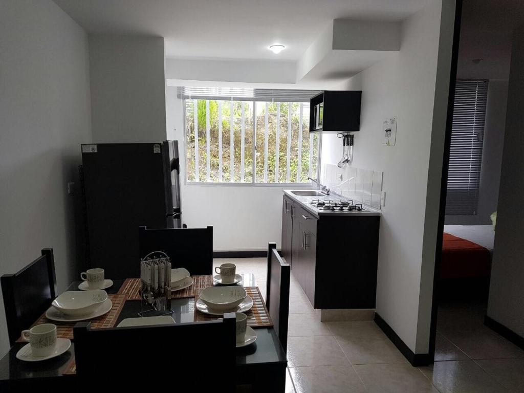 a kitchen with a table and a kitchen with a stove at Alojate a 3 minutos del Parque del Cafe in Montenegro