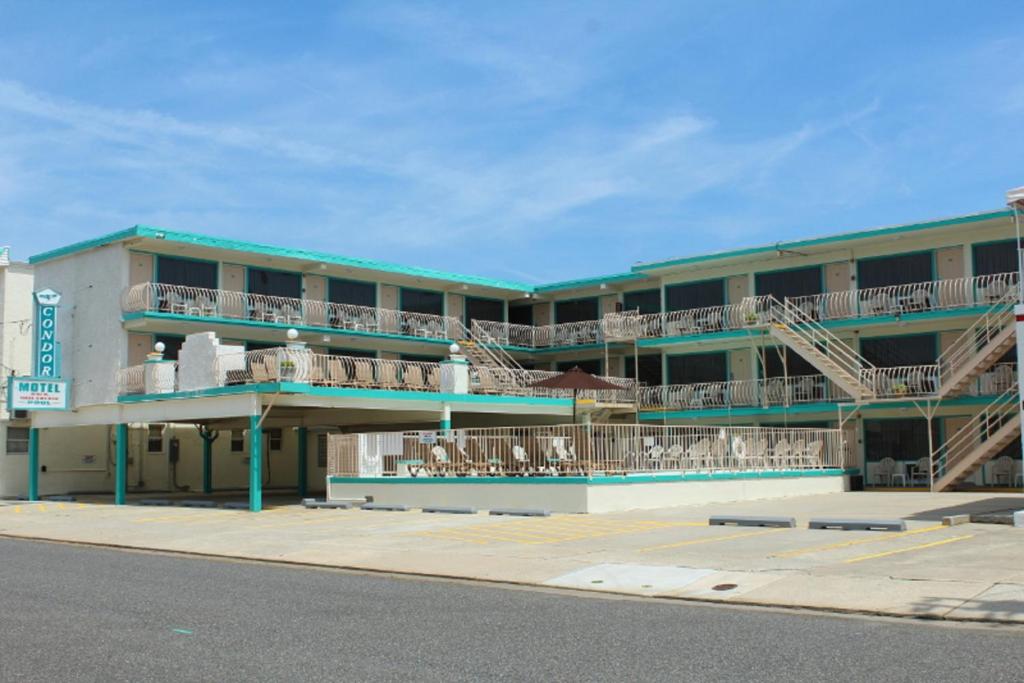 ein Gebäude mit Balkonen, Tischen und Stühlen auf einer Straße in der Unterkunft Condor Motel - Beach Block in North Wildwood