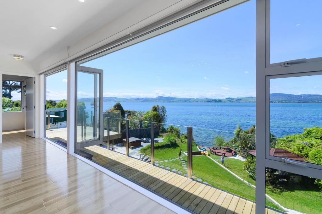 a house with a view of the water at Rotorua Luxury lakeside Resort in Rotorua