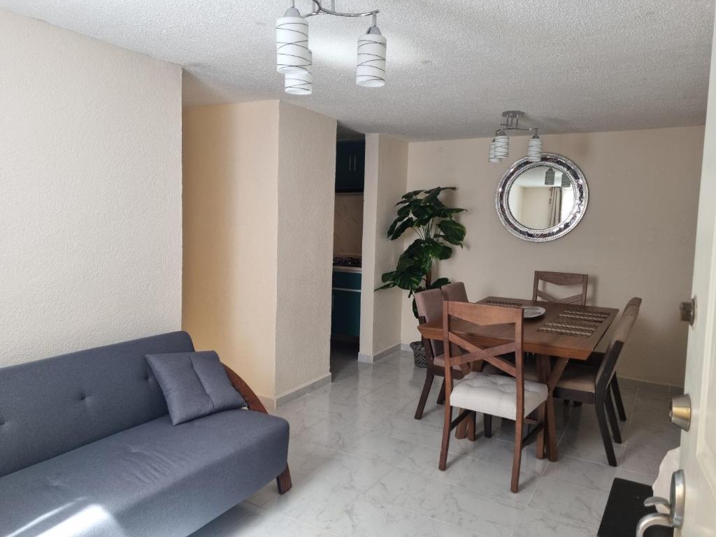 una sala de estar con un sofá y una mesa en El depa de Natalia a min de aeropuerto y estadio GNP, en Ciudad de México