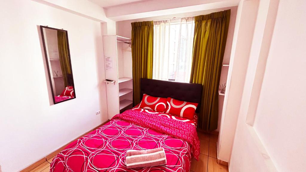 una camera con letto rosa con cuscini rossi di I Relajante Habitación en Miraflores Central a Lima