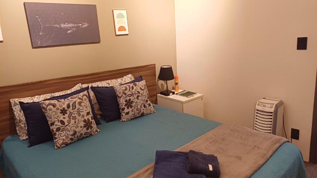 a bedroom with a bed with blue sheets and pillows at Apartamento Cambui - Centro de Convivência in Campinas