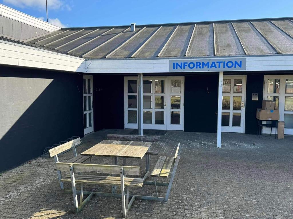 a building with a table and benches in front of it at 4 person holiday home in Hampen in Hampen