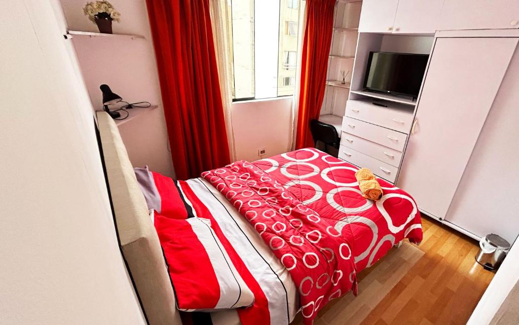 - une chambre dotée d'un lit avec une couverture rouge et blanche dans l'établissement III Acogedora Habitación Privada en Miraflores City, à Lima