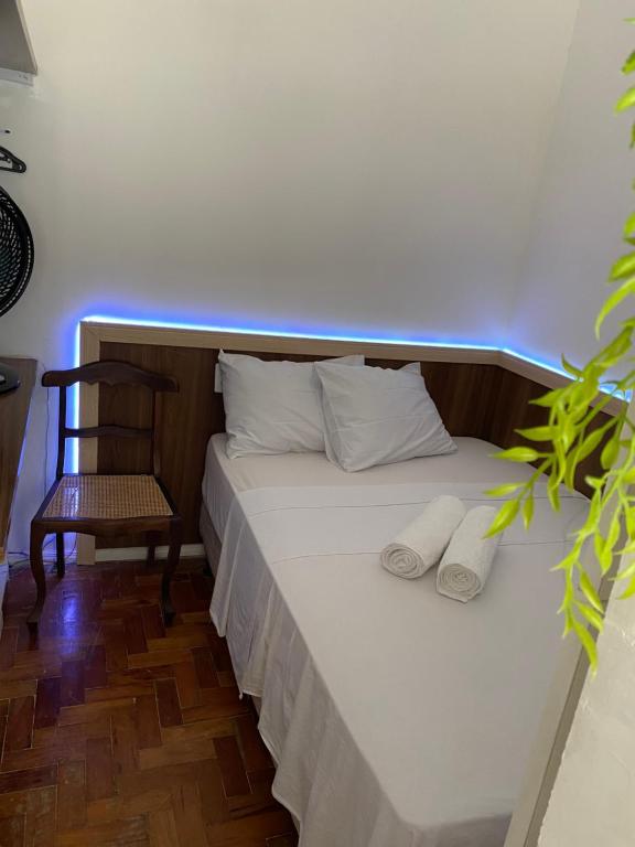 a bed with two pillows and a chair in a room at Kitnet compacta in Salvador