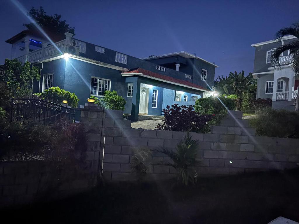 a blue house with stairs in front of it at night at Paradise stay villa #1 in Breadnut Hill