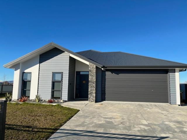 a house with a large garage in front of it at Jack Adamson Retreat in Twizel