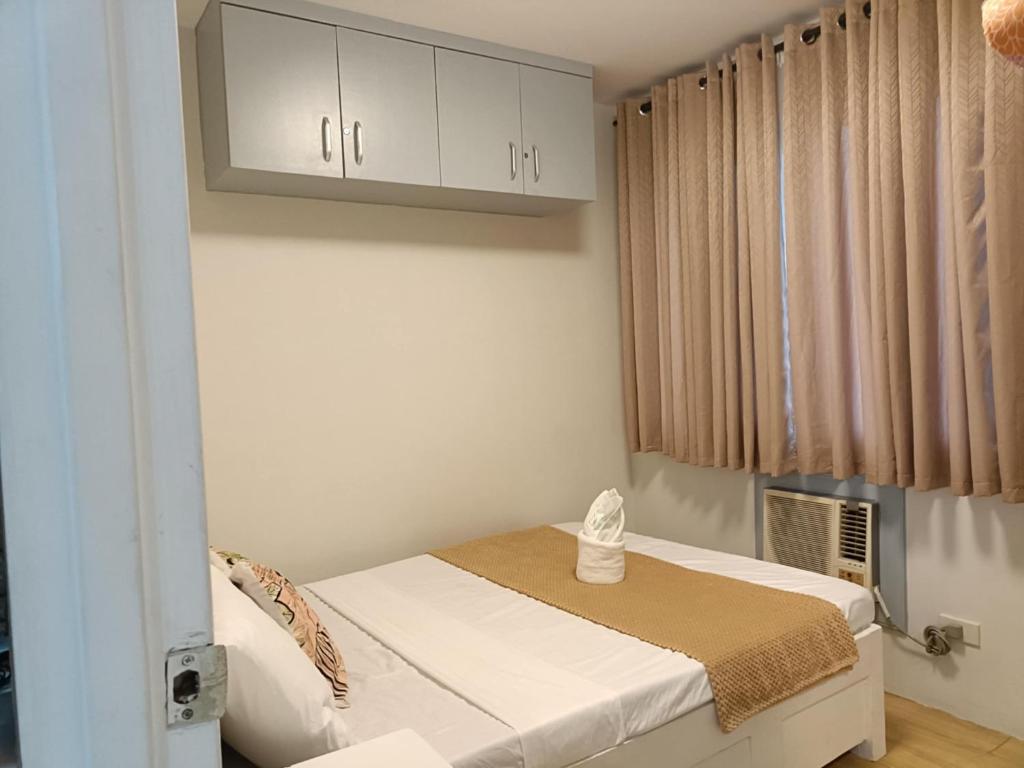 a small room with a bed and a cabinet at One Oasis 2br Condo in Davao City