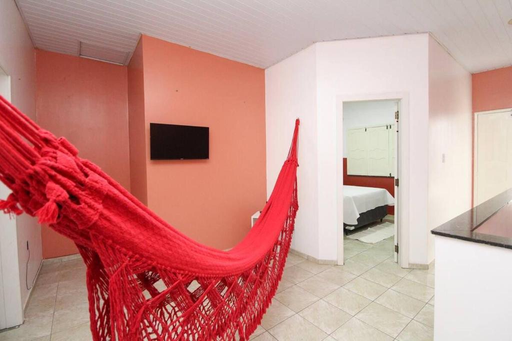 a red hammock in a room with a bedroom at Casa paraíso dos pássaros in Belém