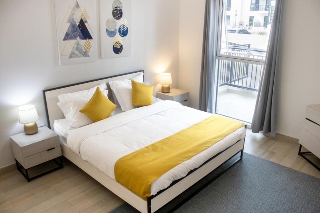 - une chambre avec un lit doté de draps jaunes et une fenêtre dans l'établissement Bright&spacious 2bd Yas Island, à Abu Dhabi