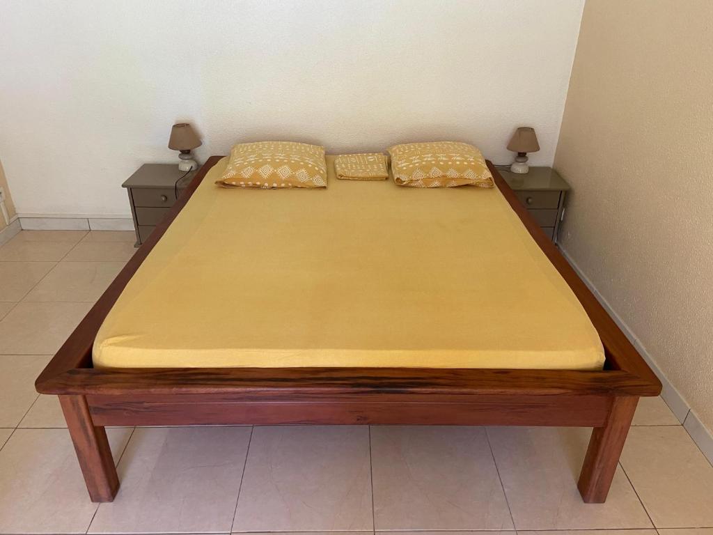 una cama con dos almohadas encima en Madiana plage, en Schœlcher