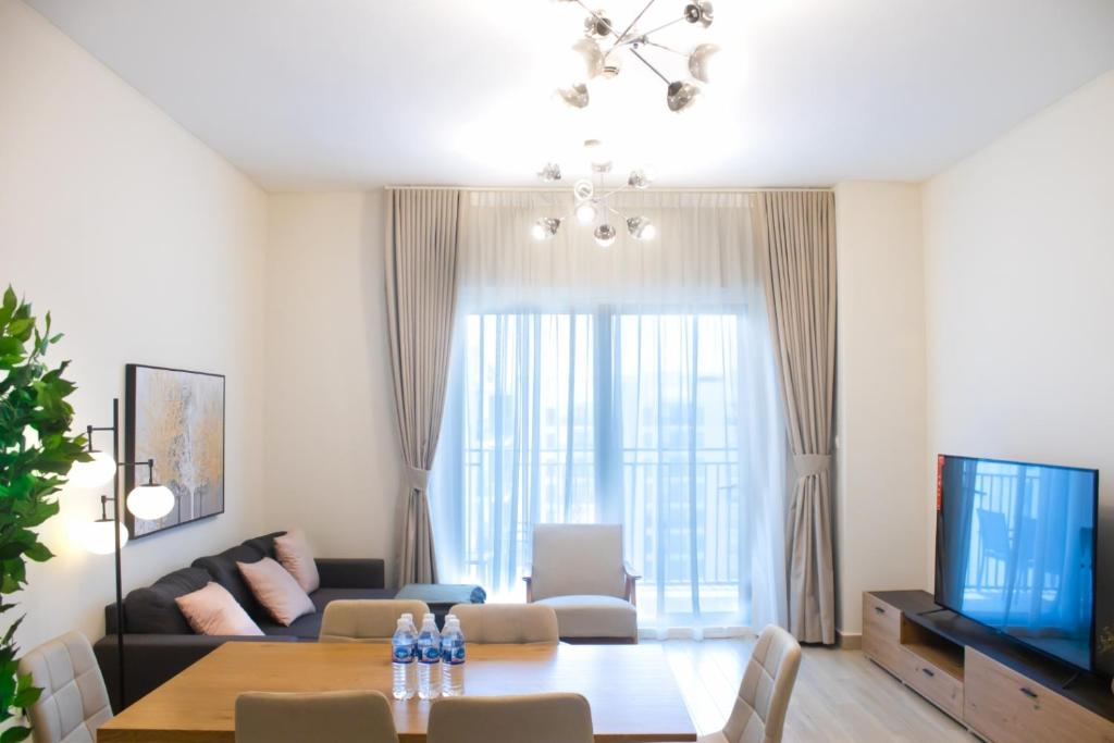 un soggiorno con un tavolo e una TV di 2br Spacious Apt At Yas Island a Abu Dhabi
