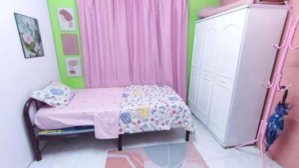 a small bedroom with a bed and a dresser at FourtyOne Homestay Mentakab Pahang in Mentekab