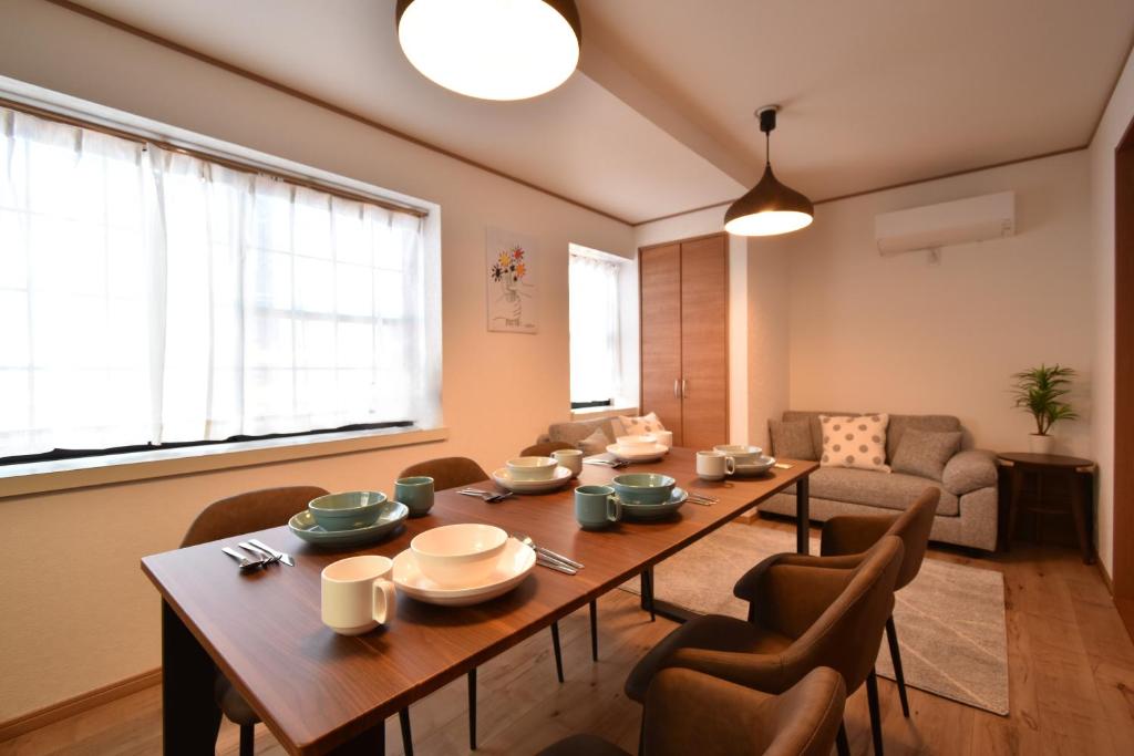 Una sala de estar con una mesa y sillas de madera. en Shinkoiwa 3BR house, en Tokio