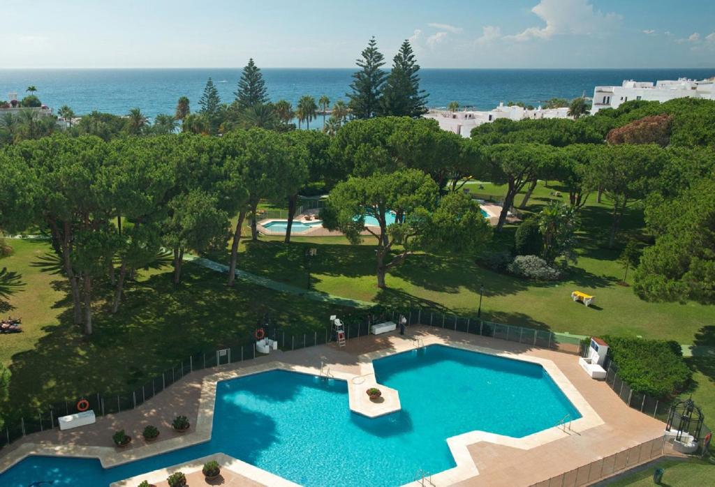 an overhead view of a swimming pool with the ocean in the background at Beachside Luxury Apartment in Puerto Banus - Club Playas del Duque in Marbella