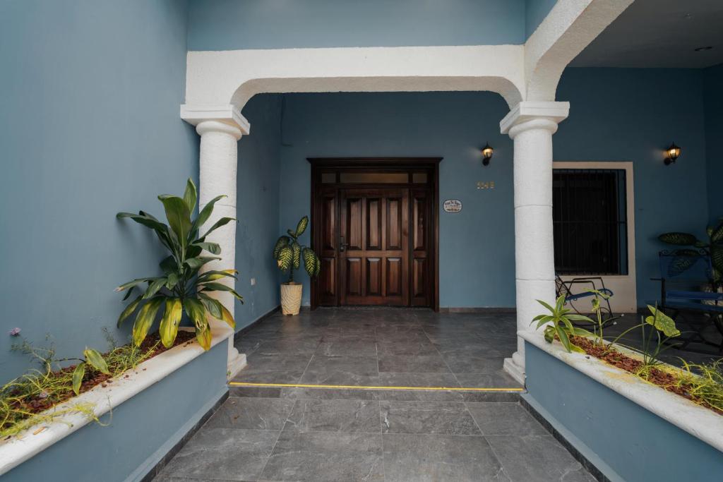 a hallway with blue walls and a wooden door at Casa Tio Roger in Mérida