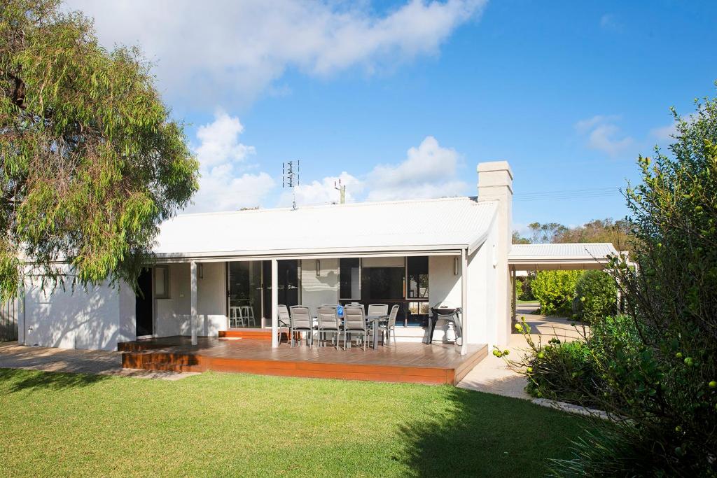 une maison blanche avec une terrasse dotée de tables et de chaises dans l'établissement Gifford Getaway - Coastal Home in Dunsborough, à Dunsborough