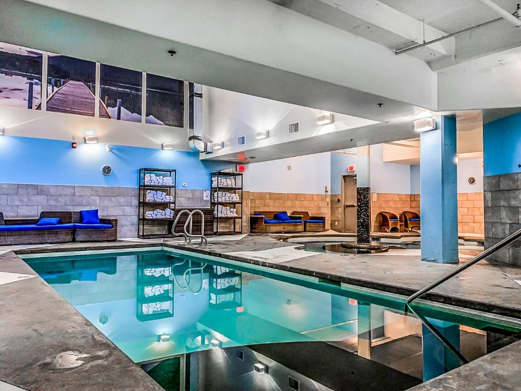 ein Hallenbad mit blauem Wasser in einem Gebäude in der Unterkunft Solara 2BR Retreat - Pool - Hot Tub & Resort Perks in Canmore