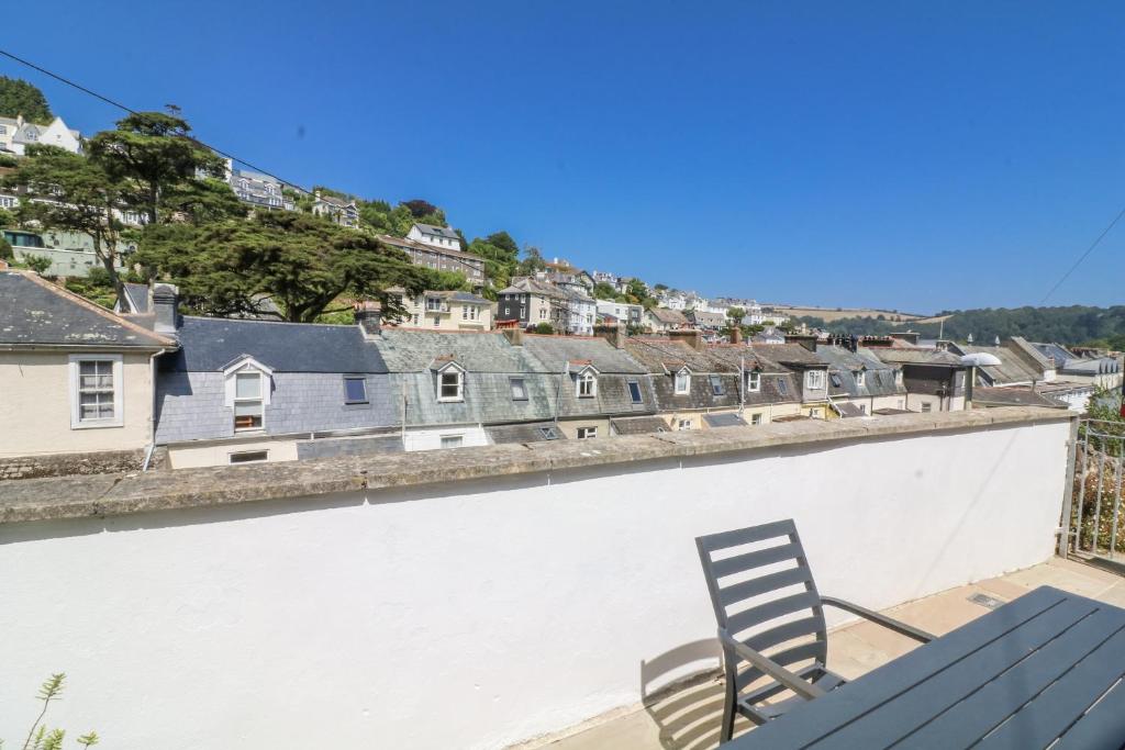 ein Stuhl auf dem Dach eines Gebäudes mit Häusern in der Unterkunft Armada Cottage in Dartmouth