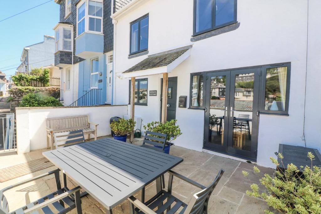 a patio with a table and chairs in front of a house at Armada Cottage in Dartmouth