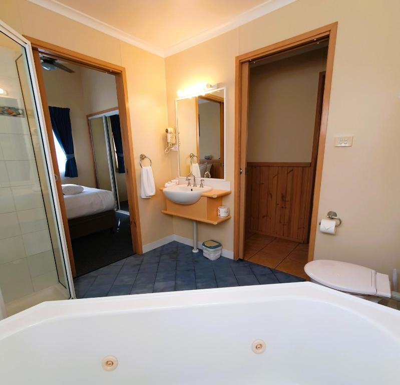 una camera d'albergo con lavandino e bagno di Pleasurelea Tourist Resort & Caravan Park a Batemans Bay